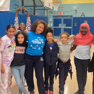Girls on the Run coach is smiling a with program participants
